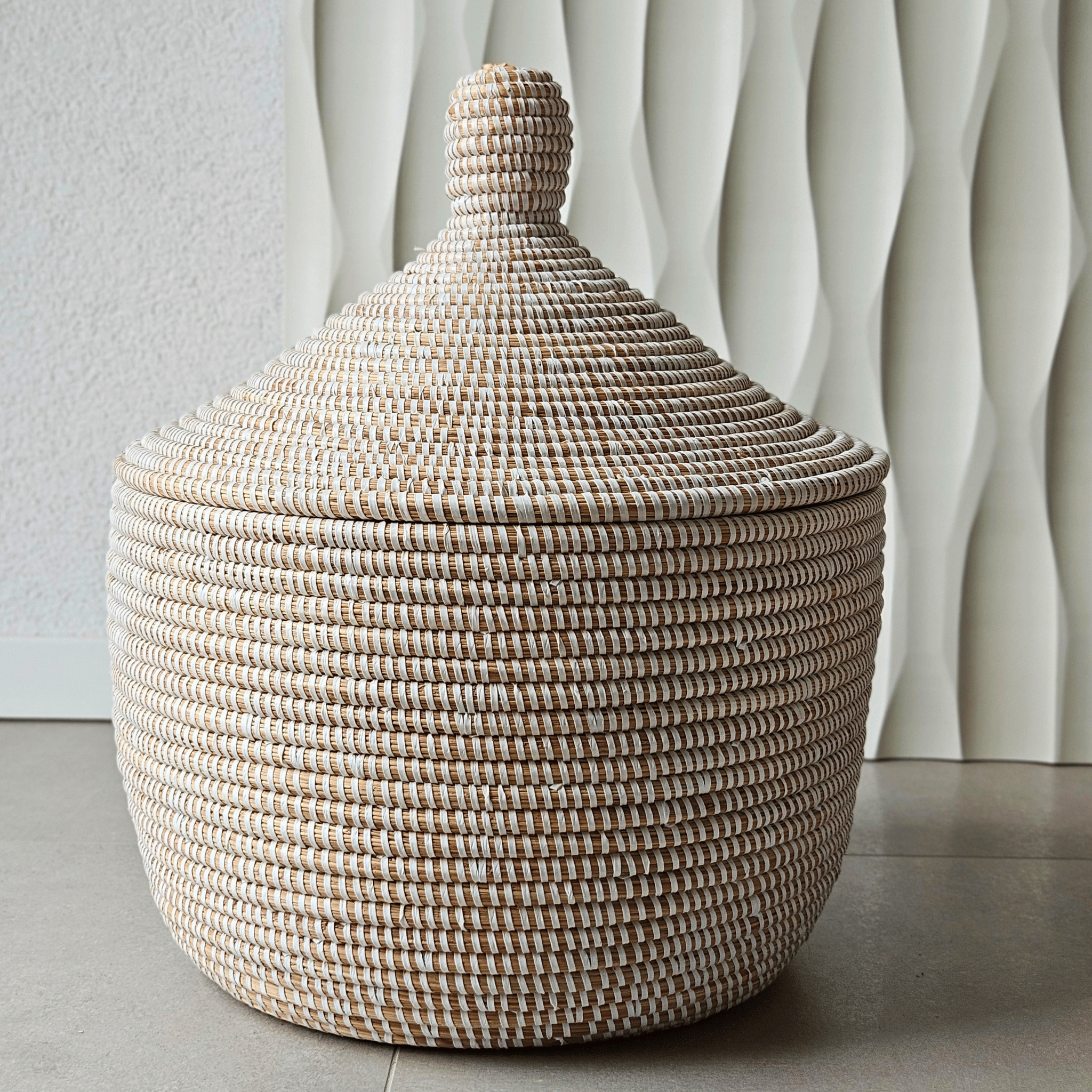 Image d'un panier de rangement tressé blanc rond avec couvercle en fibres naturelles
