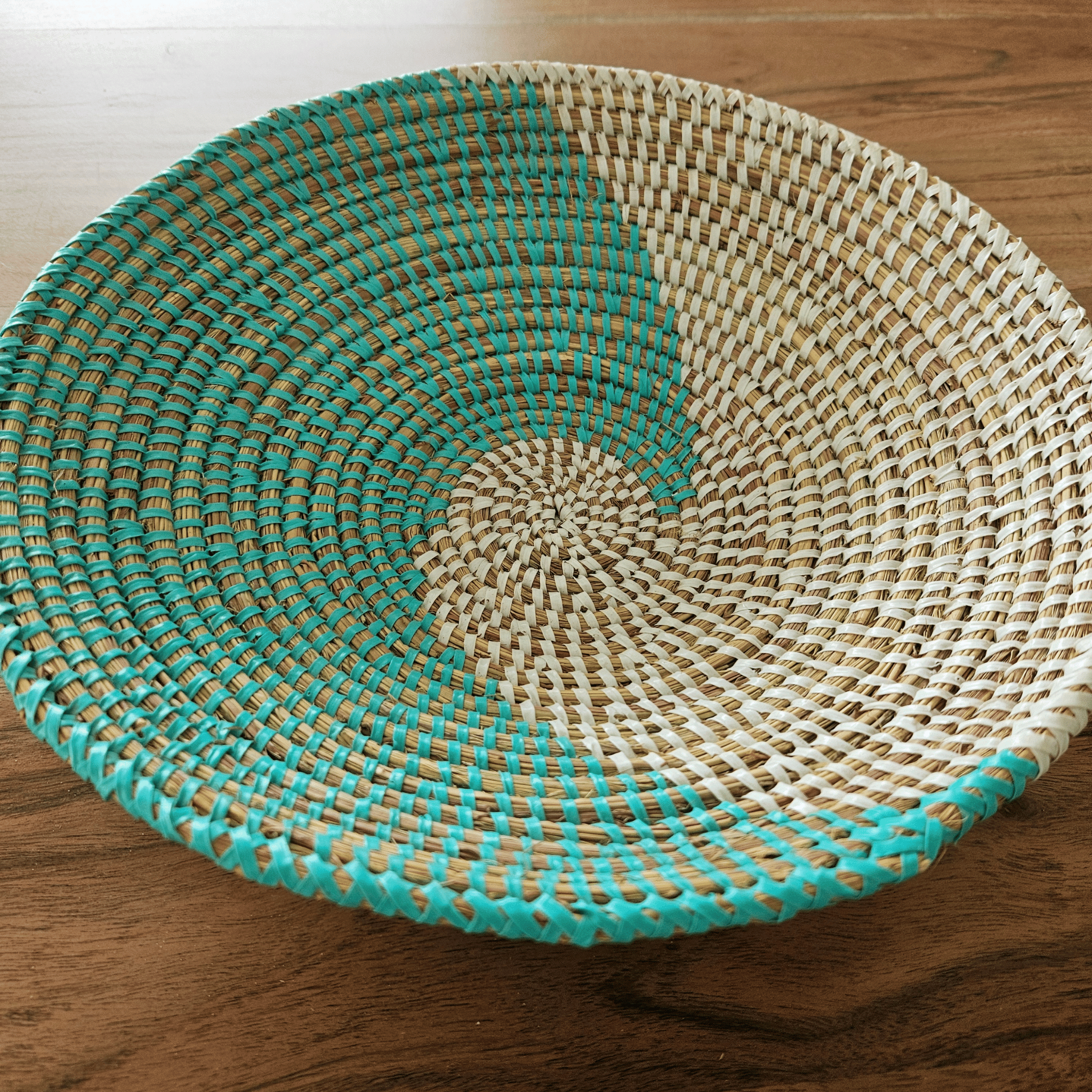 Image d'un panier rond tressé blanc et turquoise pour cuisine salle à manger élégante