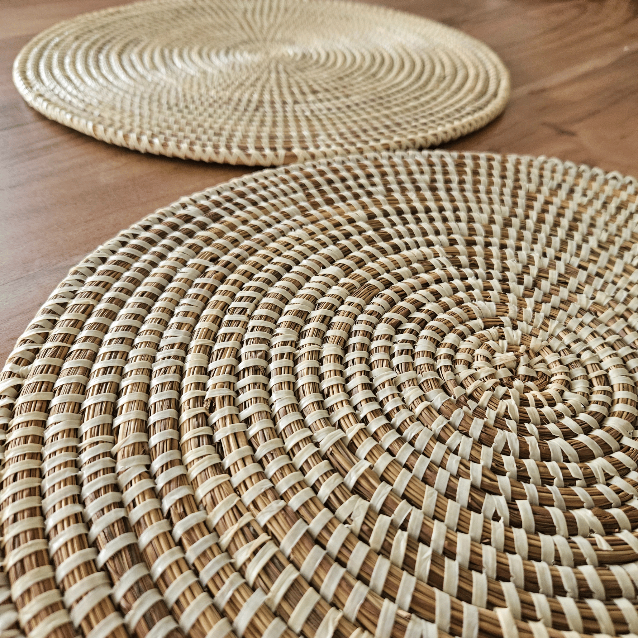 Image de deux sets de table beiges ronds tressés en fibres naturelles