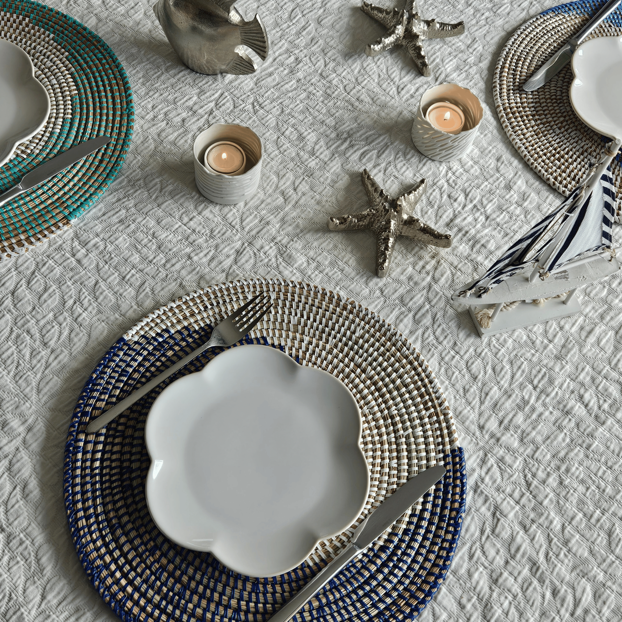 Image d'une table avec sets de table tressés blancs et bleus ronds