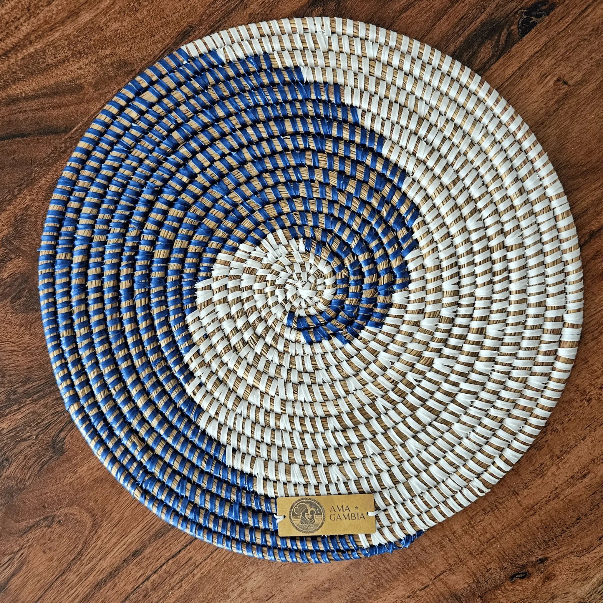 Image d'un set de table artisanal africain tressé rond blanc et bleu