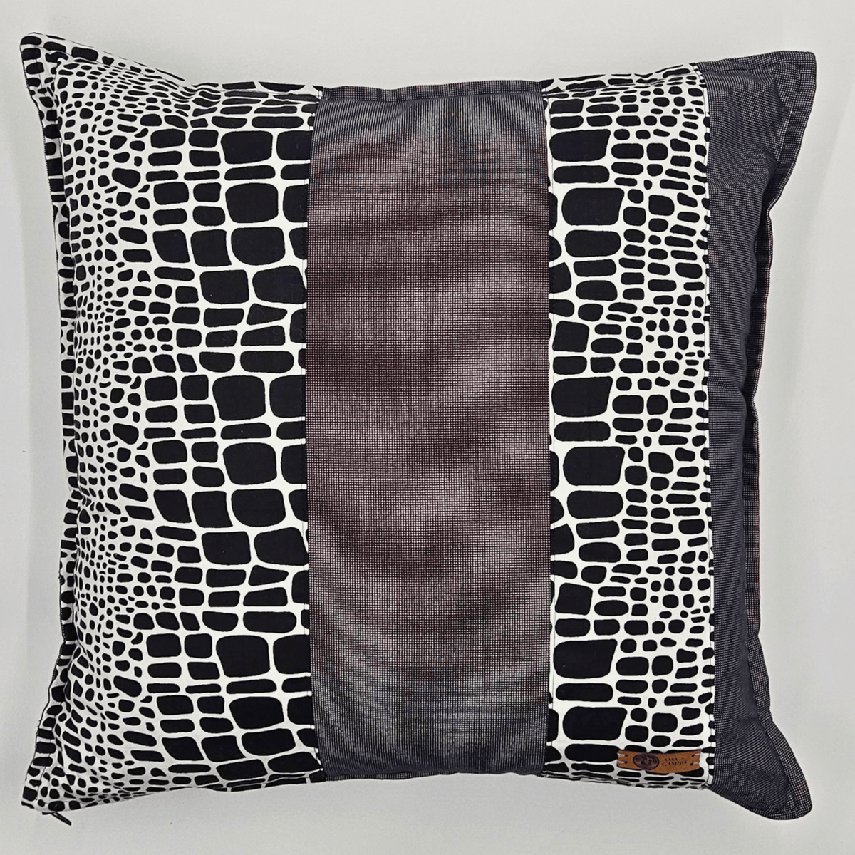 Image d'un coussin en tissu wax noir et blanc et tissu uni gris