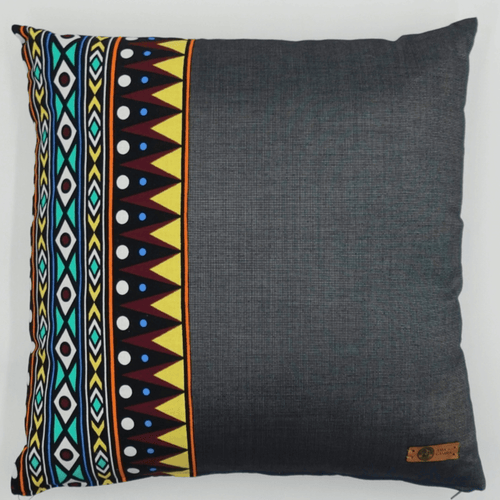 Image d'un coussin en wax motifs graphiques et tissu gris uni