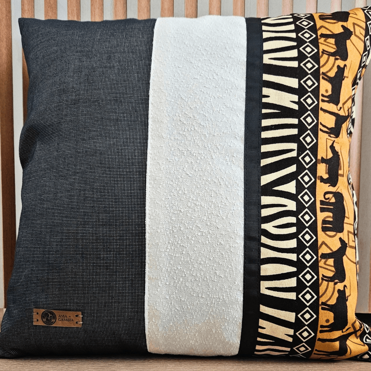 Image d'un coussin en wax, ocre, blanc, noir et gris