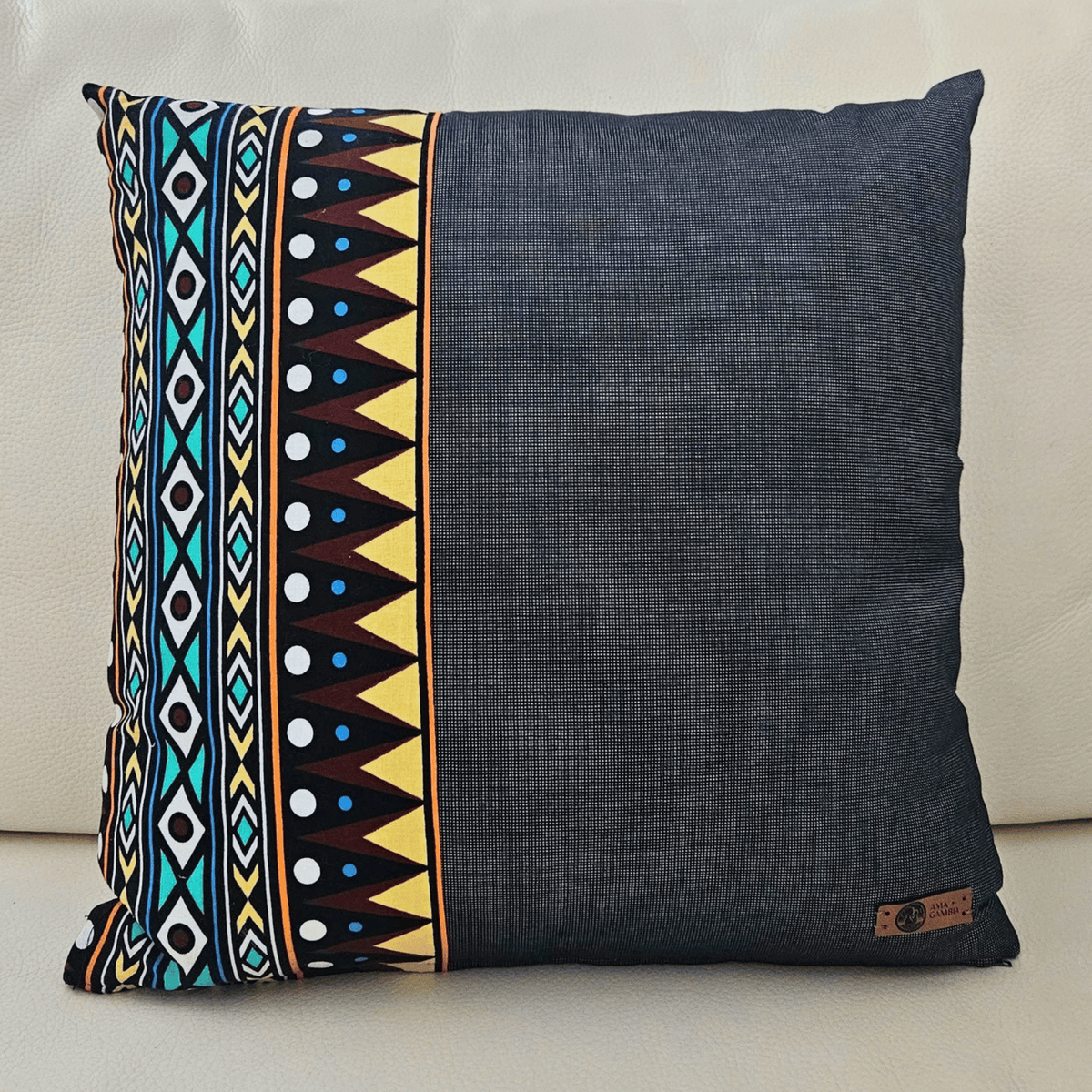 Image d'un coussin en tissu wax posé sur un canapé blanc