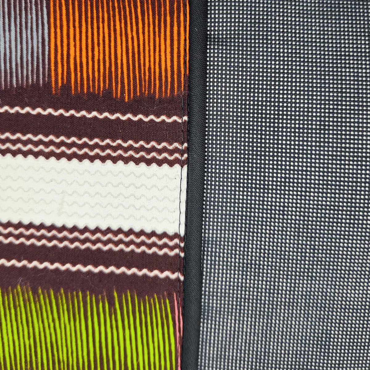 Image des détails d'un coussin tissu wax et tissu gris uni