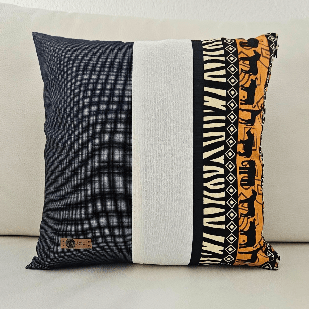 Image d'un coussin en wax avec motifs d'animaux sur canapé blanc