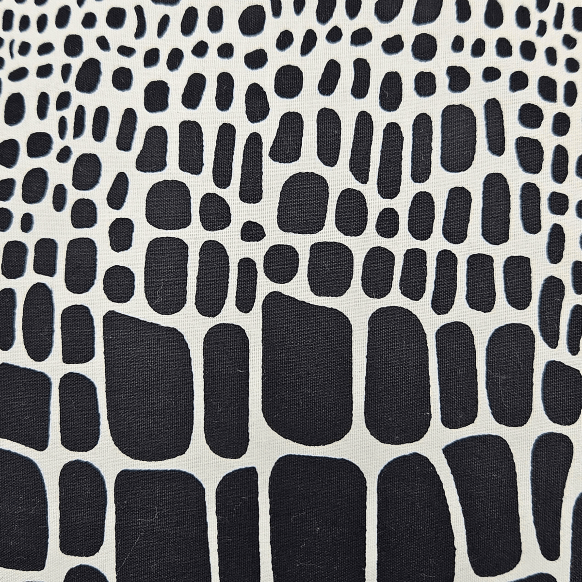 Image d'une housse de coussin en tissu wax noir et blanc, aperçu des détails