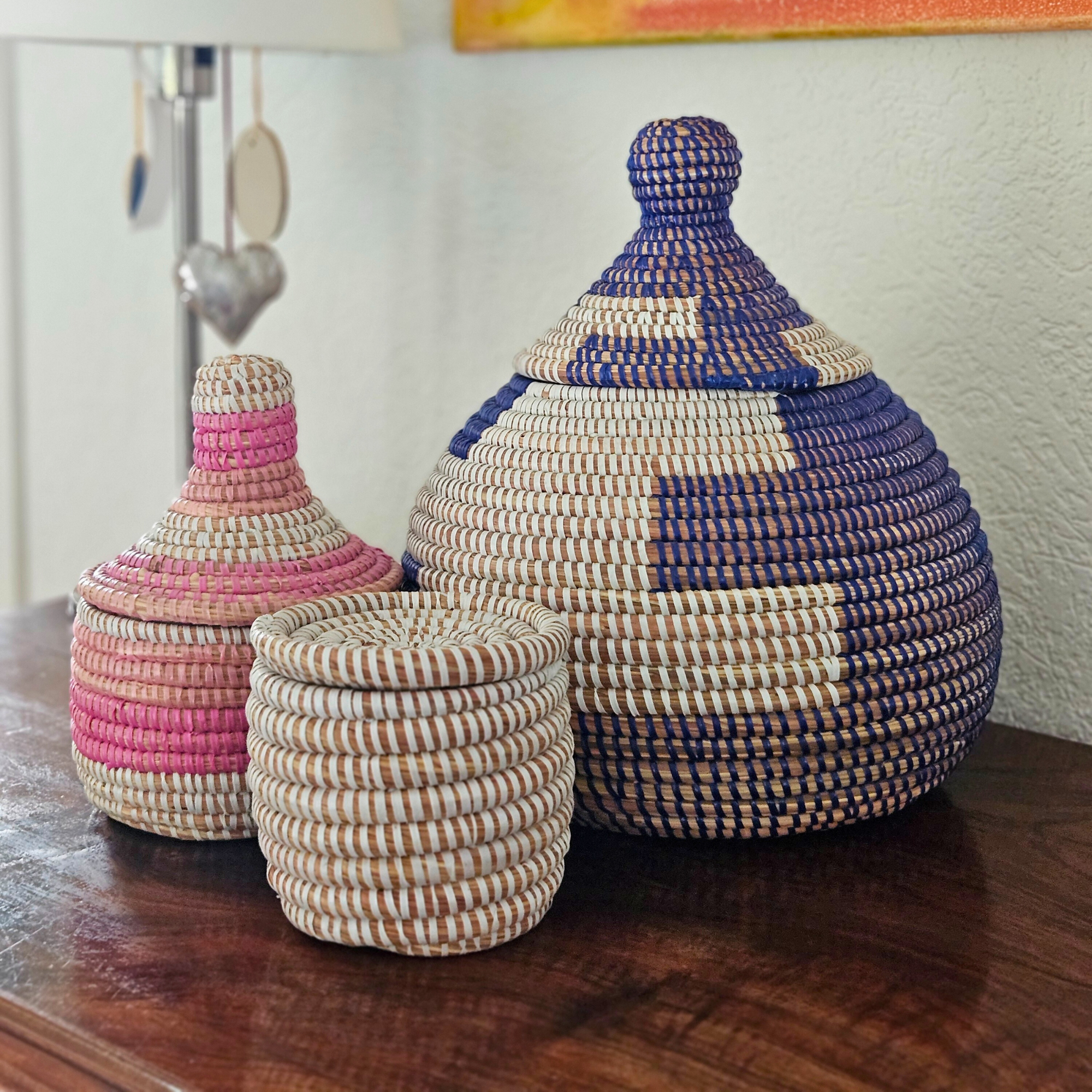 Image de paniers colorés tressés posés sur un meuble de salon